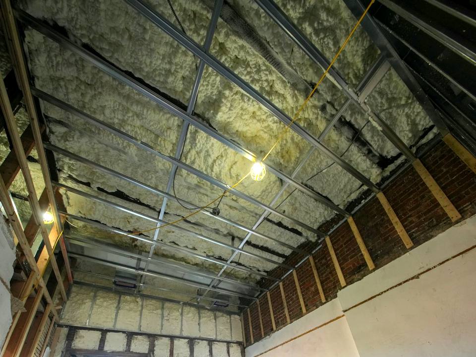 Spray foam insulation in open wall and roof framing
